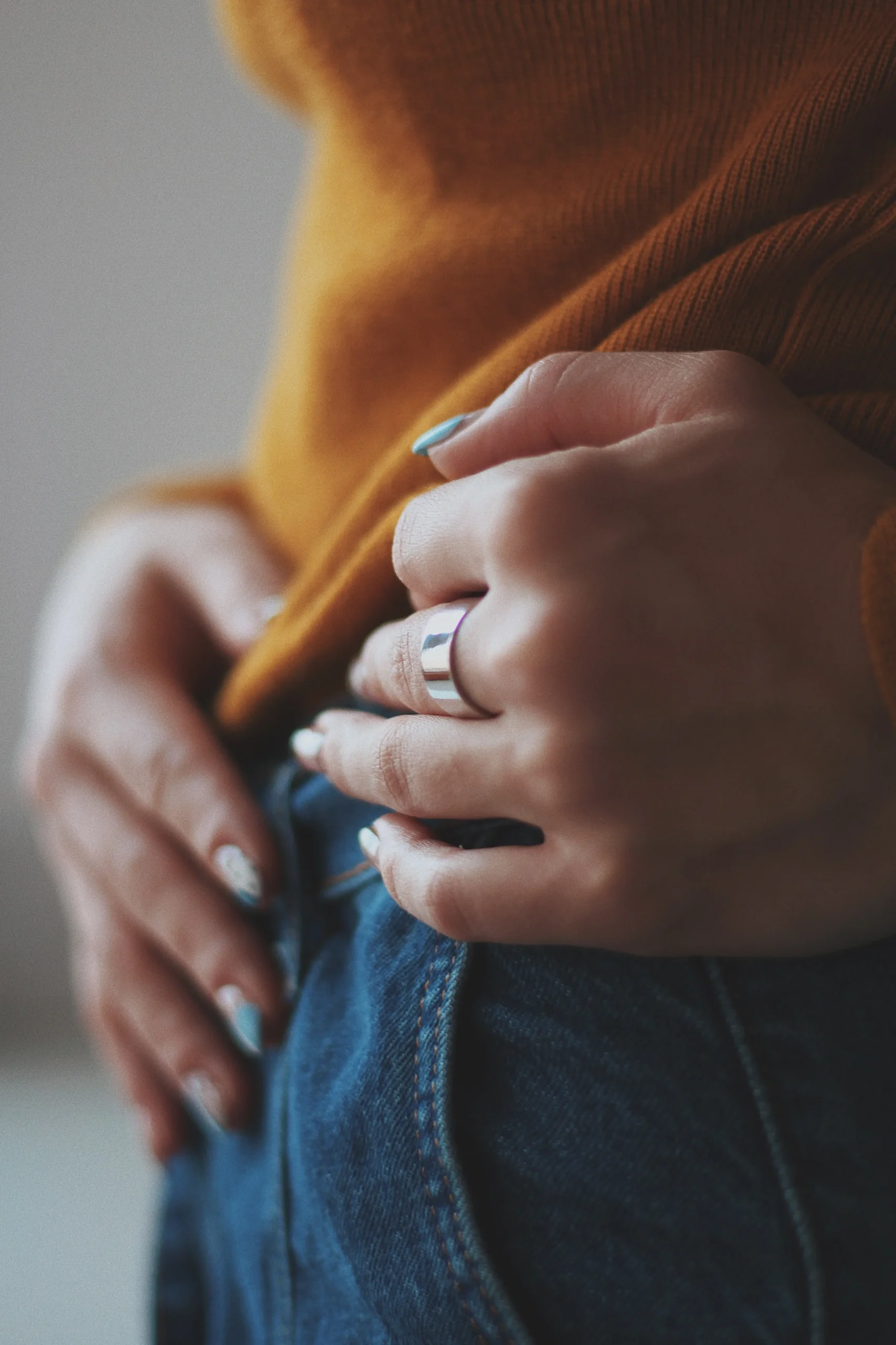 vertical-closeup-shot-female-orange-shirt-wearing-expensive-golden-ring